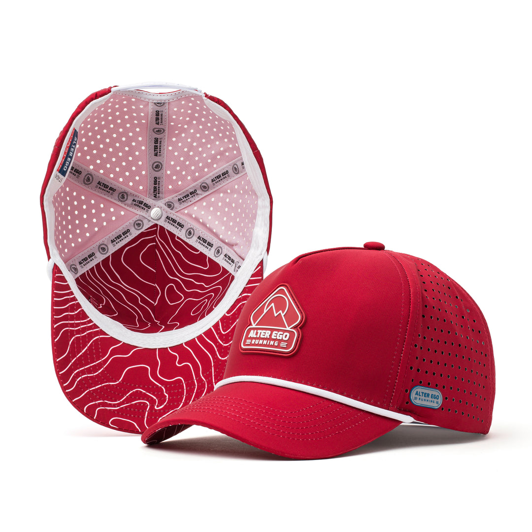 Red performance hat with a white mountain logo on the front and a breathable red patterned mesh back, designed for outdoor adventures and active wear.