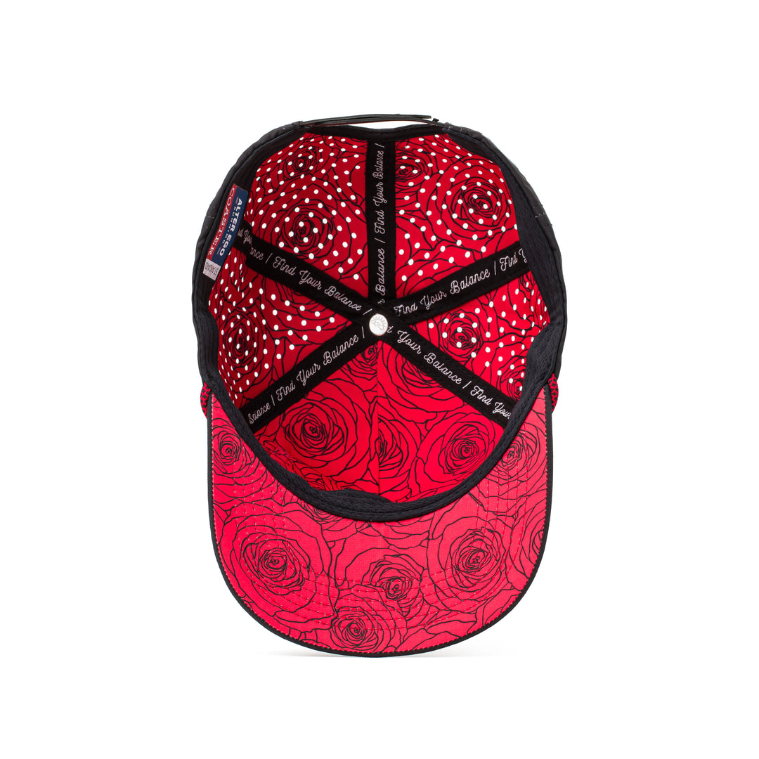 Interior and back view of a black hat featuring red patterned mesh panels, an adjustable strap, and a sweat-wicking lining for active use.